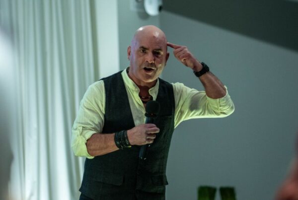 Kevin Bulmer speaking at a Little Engines event, pointing to his head to illustrate mindset and leadership alignment.
