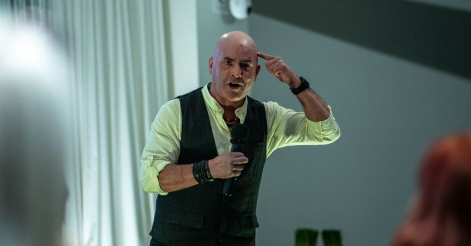 Kevin Bulmer speaking at a Little Engines event, pointing to his head to illustrate mindset and leadership alignment.